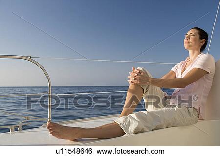 A woman relaxing on a boat View Large Photo Image Stock Photograph - A woman relaxing on a boat. Fotosearch