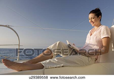 A woman relaxing with a book on a boat View Large Photo Image Stock Photo - A woman relaxing with a book on a boat. Fotosearch