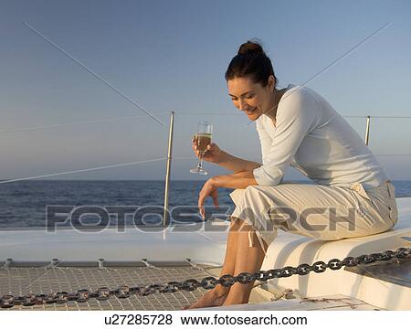 A woman relaxing with a drink on a boat View Large Photo Image Stock Photo - A woman relaxing with a drink on a boat. Fotosearch