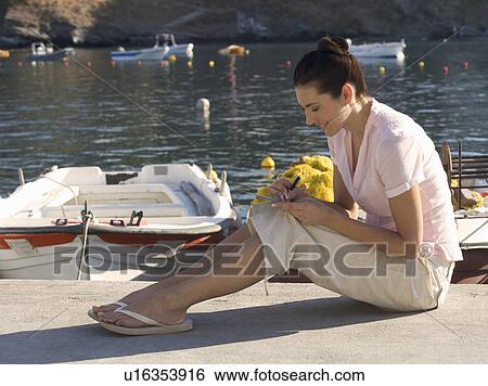 A woman sitting by a harbour writing a postcard View Large Photo Image Stock Photograph - A woman sitting by a harbour writing a postcard. Fotosearch