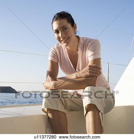A woman sitting on the edge of a boat View Large Photo Image Stock Image - A woman sitting on the edge of a boat. Fotosearch