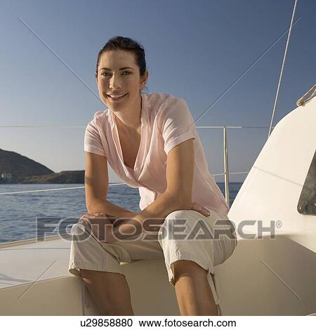 A woman sitting on the edge of a boat View Large Photo Image Stock Image - A woman sitting on the edge of a boat. Fotosearch