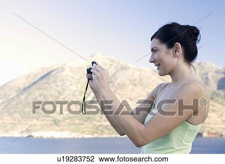 A woman taking a photo View Large Photo Image Stock Image - A woman taking a photo. Fotosearch