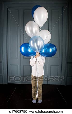Stock Image - boy hiding behind a bunch of balloons. Fotosearch
