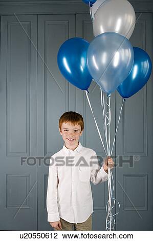 Stock Image - boy holding a bunch of balloons. Fotosearch