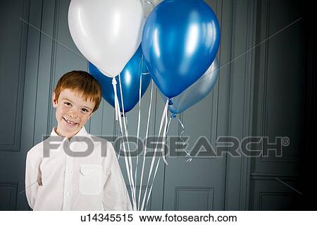 Stock Photography - boy holding bunch of balloons. Fotosearch