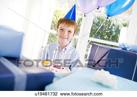 Boy with birthday cake at party View Large Photo Image Stock Image - Boy with birthday cake at party. Fotosearch
