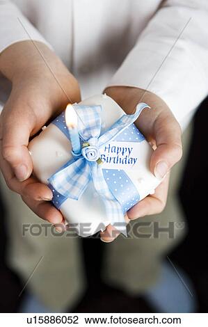 Stock Image - close up shot hands holding miniature birthday cake. Fotosearch
