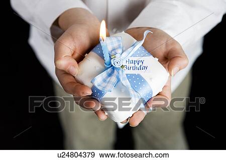 Stock Photo - close up shot hands holding miniature birthday cake. Fotosearch