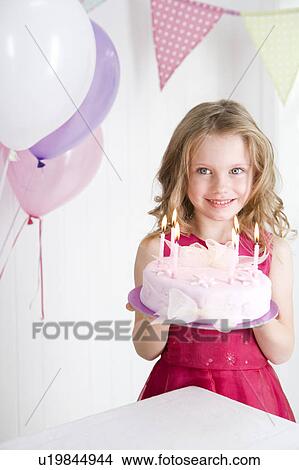 Picture - happy little girl holding birthday cake. Fotosearch