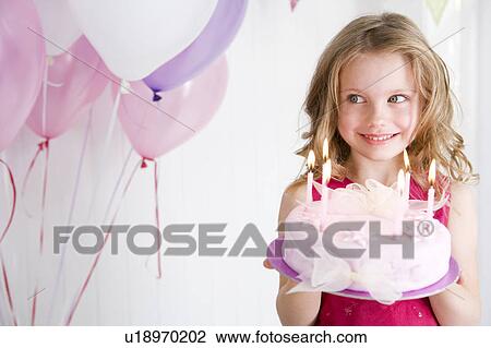 Stock Image - happy little girl holding birthday cake. Fotosearch