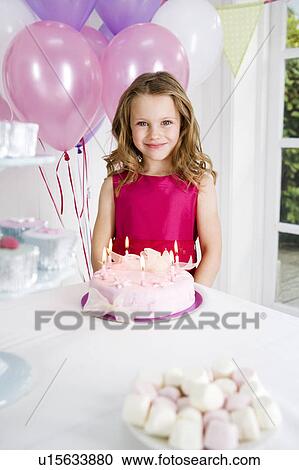 little girl standing in front of birthday cake on tea table View Large Photo Image Stock Image - little girl standing in front of birthday cake on tea table. Fotosearch