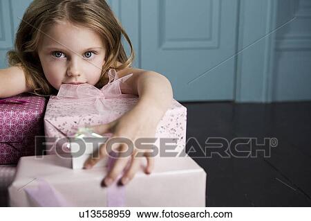 Stock Photo - Young girl with birthday presents . Fotosearch