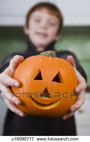 Boy holding a Jack'o Lantern for Halloween View Large Photo Image Stock Photo - Boy holding a Jack'o Lantern for Halloween . Fotosearch