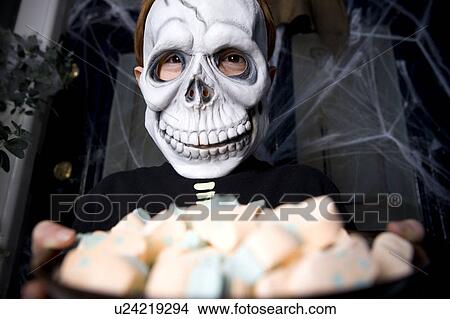 Boy in a skeleton costume at a Hallowe'en party, holding a tray of sweets View Large Photo Image Picture - Boy in a skeleton costume at a Hallowe'en party, holding a tray of sweets . Fotosearch