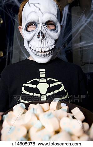 Boy in a skeleton costume at a Hallowe'en party, holding a tray of sweets View Large Photo Image Stock Photo - Boy in a skeleton costume at a Hallowe'en party, holding a tray of sweets . Fotosearch