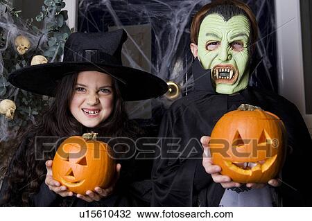 Children in Hallowe'en costumes, holding pumpkins with carved faces View Large Photo Image Stock Image - Children in Hallowe'en costumes, holding pumpkins with carved faces. Fotosearch
