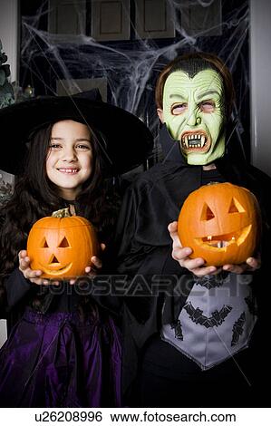 Children in Hallowe'en costumes, holding pumpkins with carved faces View Large Photo Image Stock Photograph - Children in Hallowe'en costumes, holding pumpkins with carved faces. Fotosearch