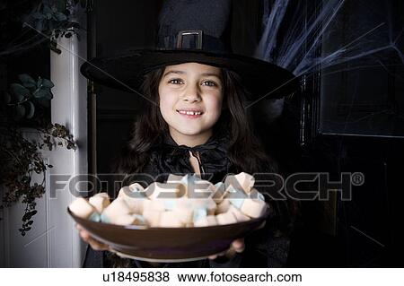 Girl in a witch's costume at a Hallowe'en party, holding a tray of sweets View Large Photo Image Stock Photo - Girl in a witch's costume at a Hallowe'en party, holding a tray of sweets. Fotosearch
