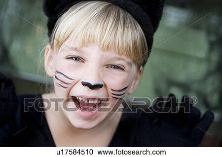 Stock Image - Little girl in a cat outfit dressed up for Halloween . Fotosearch