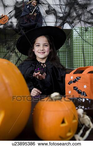 Little girl in a witch's outfit at a Halloween party View Large Photo Image Stock Photograph - Little girl in a witch's outfit at a Halloween party . Fotosearch