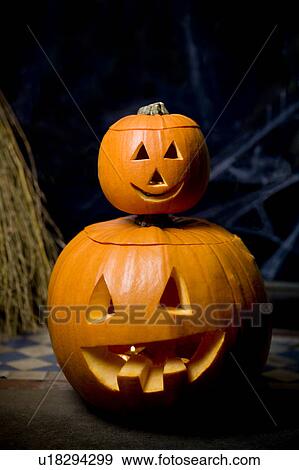 Orange Hallowe'en pumpkins with carved faces, one on top of the other View Large Photo Image Stock Photo - Orange Hallowe'en pumpkins with carved faces, one on top of the other. Fotosearch