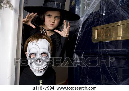 Young boy and girl at the front door, dressed up for Halloween View Large Photo Image Picture - Young boy and girl at the front door, dressed up for Halloween . Fotosearch