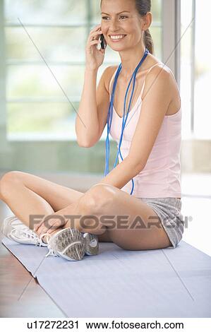 A woman sitting in a gym View Large Photo Image Stock Image - A woman sitting in a gym. Fotosearch