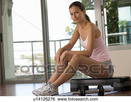 A woman sitting in a gym View Large Photo Image Stock Photograph - A woman sitting in a gym. Fotosearch