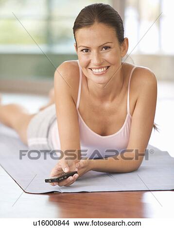 A woman using a mobile phone in a gym View Large Photo Image Picture - A woman using a mobile phone in a gym. Fotosearch