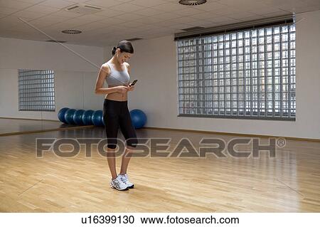 A young woman at a gym View Large Photo Image Stock Image - A young woman at a gym. Fotosearch