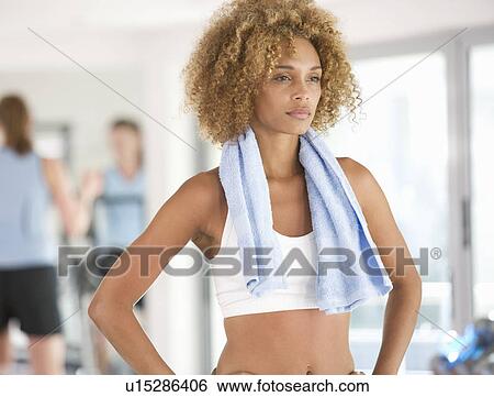 A young woman standing in a gym View Large Photo Image Stock Photograph - A young woman standing in a gym. Fotosearch
