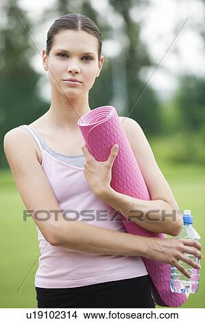 A young woman with a yoga mat View Large Photo Image Picture - A young woman with a yoga mat. Fotosearch