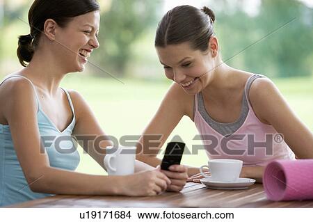 Two young women drinking coffee after a yoga class View Large Photo Image Picture - Two young women drinking coffee after a yoga class. Fotosearch