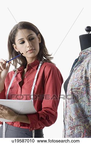 Fashion designer looking a mannequin and holding documents View Large Photo Image Stock Image - Fashion designer looking a mannequin and holding documents. Fotosearch