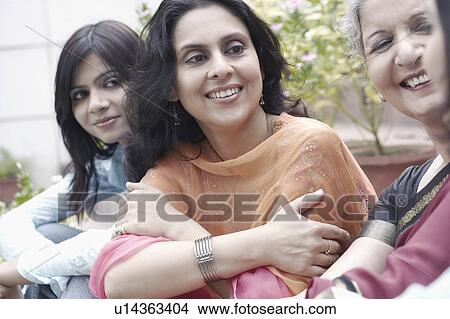 Four women sitting together smiling View Large Photo Image Picture - Four women sitting together smiling. Fotosearch