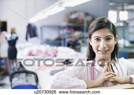 Portrait of a female fashion designer in a textile industry and smiling View Large Photo Image Stock Photograph - Portrait of a female fashion designer in a textile industry and smiling. Fotosearch