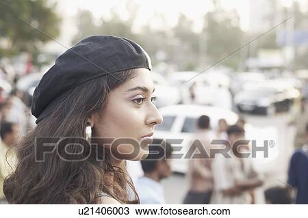 Stock Image - Side profile of a young woman wearing a cap. Fotosearch