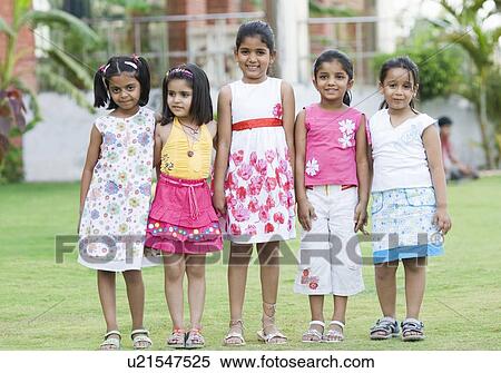 Stock Photography - Five girls standing in a lawn and smiling. Fotosearch