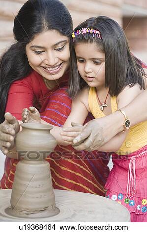 Girl with her teacher in a pottery class View Large Photo Image Picture - Girl with her teacher in a pottery class. Fotosearch