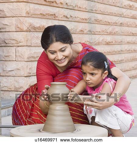 Girl with her teacher in a pottery class View Large Photo Image Stock Image - Girl with her teacher in a pottery class. Fotosearch
