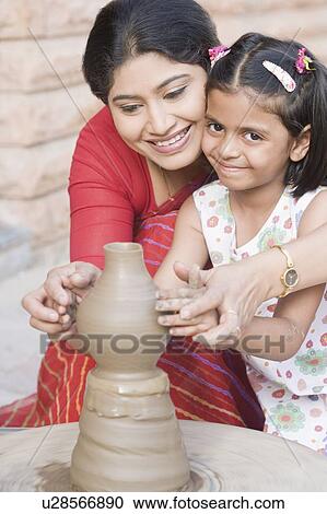 Girl with her teacher in a pottery class View Large Photo Image Stock Image - Girl with her teacher in a pottery class. Fotosearch