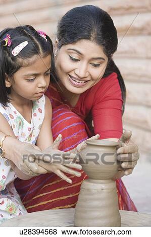 Stock Photo - Girl with her teacher in a pottery class. Fotosearch