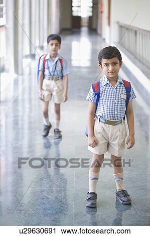Stock Image - Portrait of a boy standing in the corridor of a school. Fotosearch