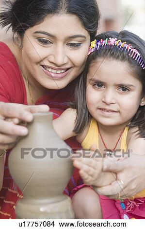 Picture - Portrait of a girl with her teacher in a pottery class. Fotosearch