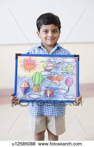 Portrait of a schoolboy holding a painting and smiling View Large Photo Image Stock Photo - Portrait of a schoolboy holding a painting and smiling. Fotosearch