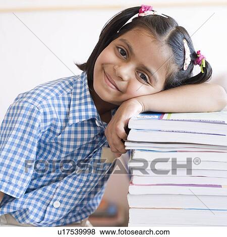 Portrait of a schoolgirl leaning over a stack of books and smiling View Large Photo Image Stock Photo - Portrait of a schoolgirl leaning over a stack of books and smiling. Fotosearch