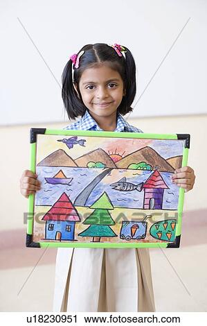 Stock Image - Portrait of a schoolgirl showing a drawing and smirking. Fotosearch