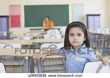 Portrait of a schoolgirl with her teacher sitting in the background View Large Photo Image Stock Photo - Portrait of a schoolgirl with her teacher sitting in the background. Fotosearch