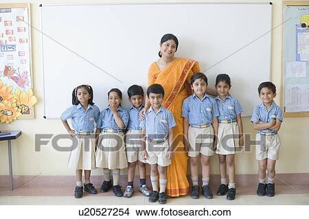 Portrait of a teacher standing with schoolchildren and smiling View Large Photo Image Picture - Portrait of a teacher standing with schoolchildren and smiling. Fotosearch